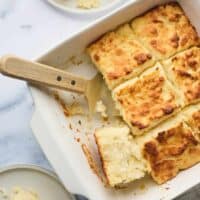 a 9x9 pan with butter swim biscuits two of them removed.