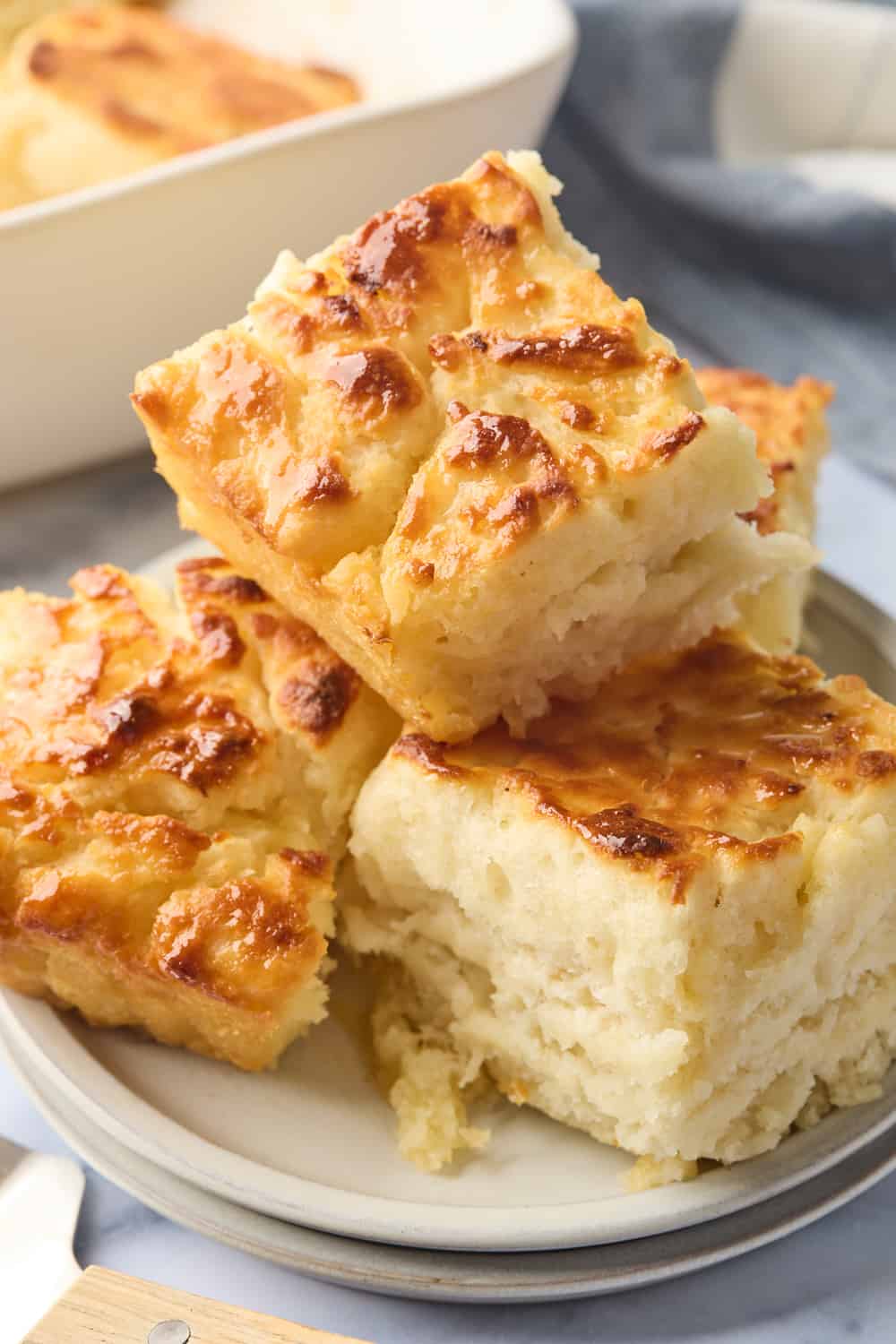 A stack of butter swim biscuits on a cream plate on a marble background ready to enjoy after baking.