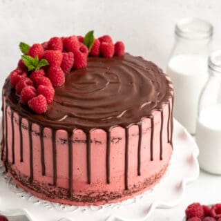 raspberry chocolate cake with fresh raspberries on top and a pink buttercream
