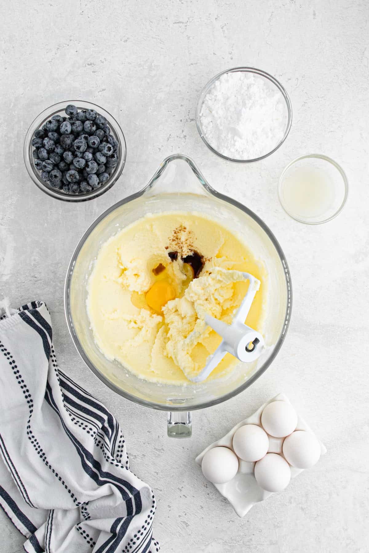 Butter, sugar, eggs, and vanilla mixing in a stand mixer bowl