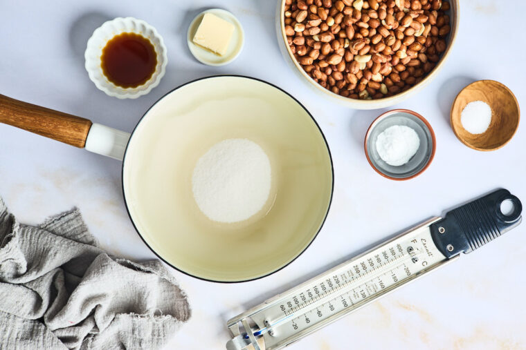 Spanish peanuts, salt, butter, vanilla, sugar on white countertop