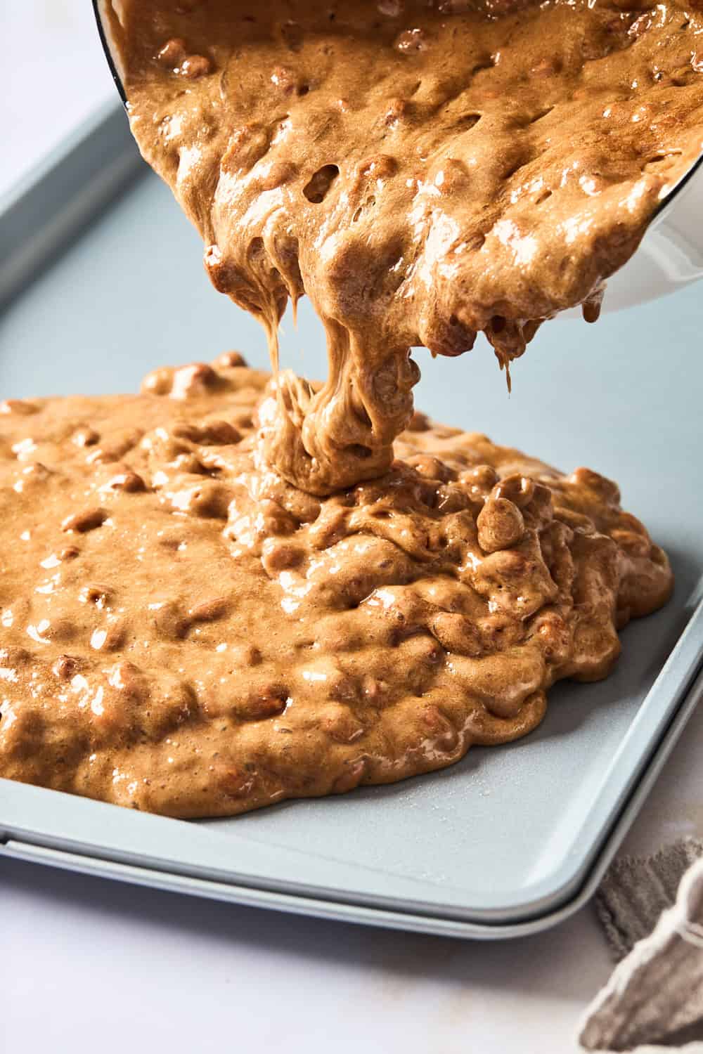 Brittle candy mixture being poured on baking sheet