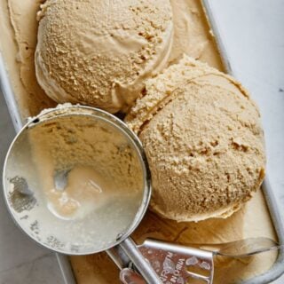 Close up of coffee ice cream being scooped on the ice cream container