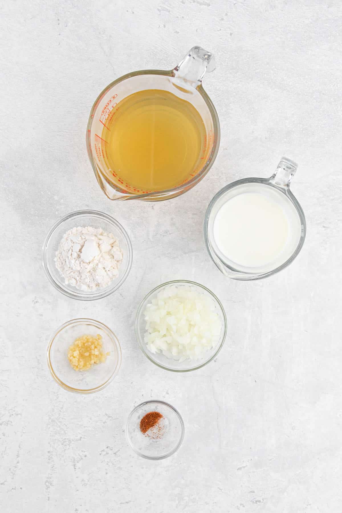 Spices, flour and liquids to make a delicious chicken fried steak gravy on a white background