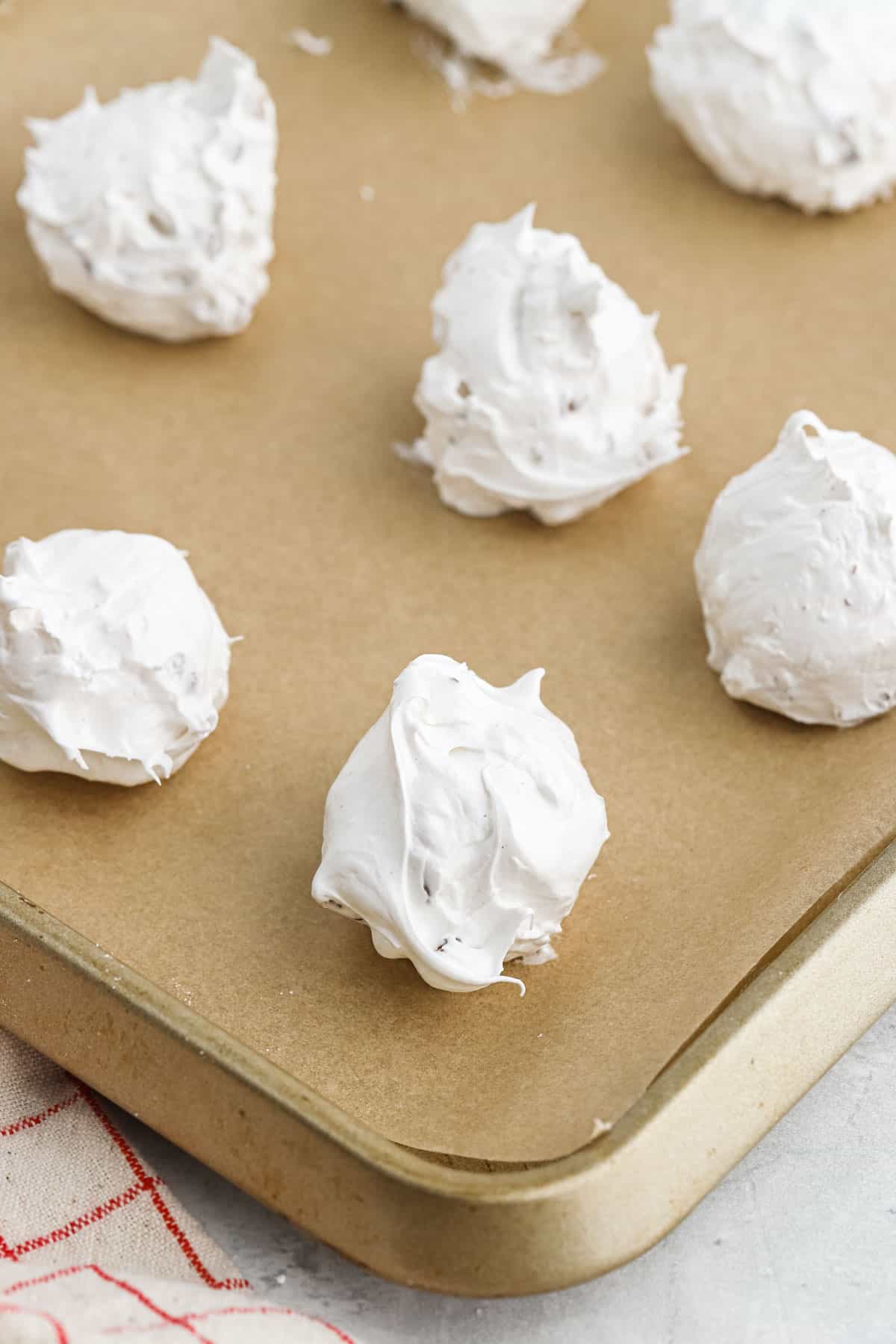 Divinity candy on a baking sheet with parchment paper surrounded by more divinity candy