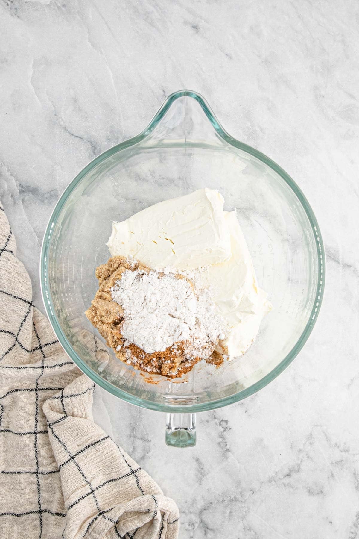 Cream cheese, brown sugar, flour, and cinnamon in a glass mixing bowl