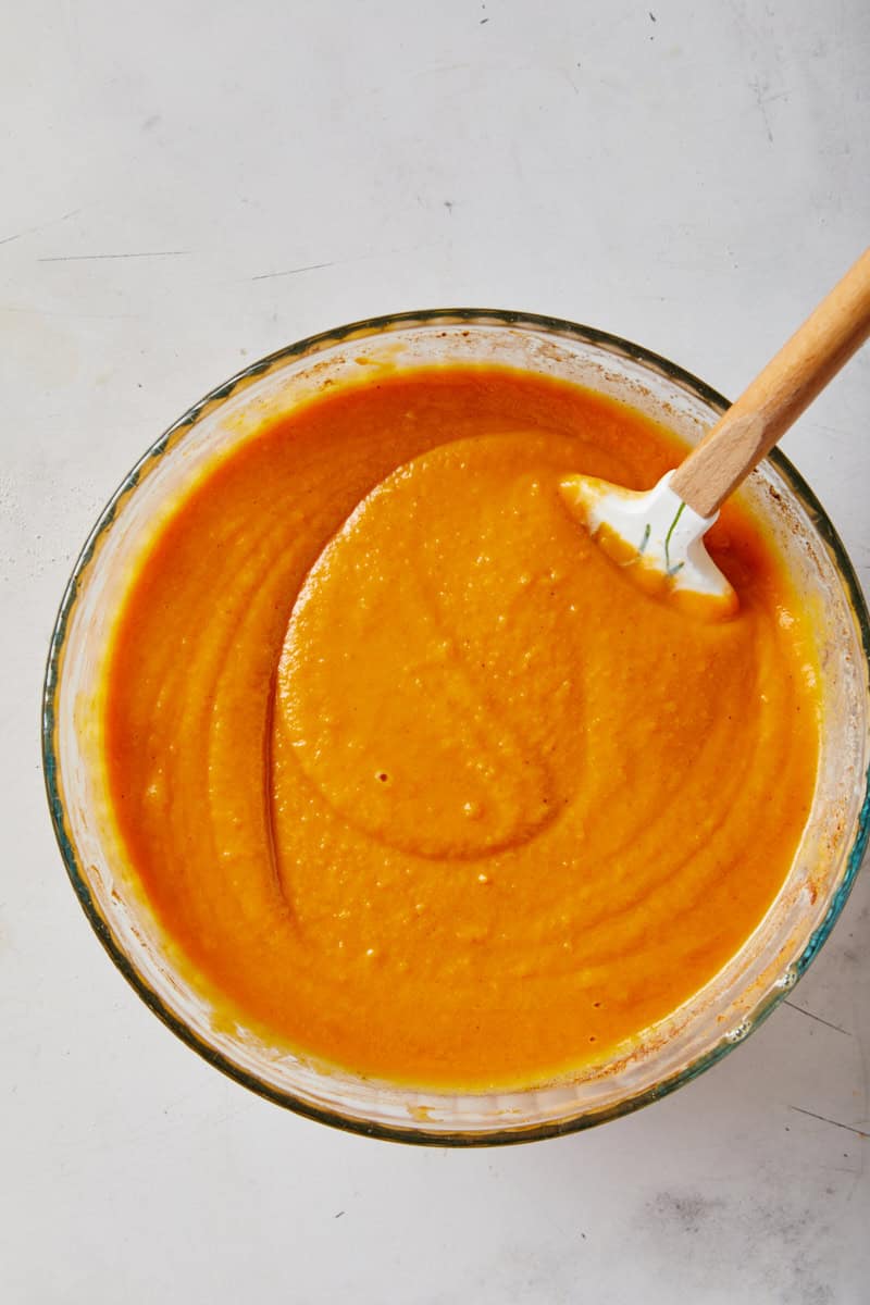 Smooth African American sweet potato pie recipe filling in a bowl with spatula stirring on white countertop