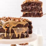 A slice of chocolate turtle cake being lifted