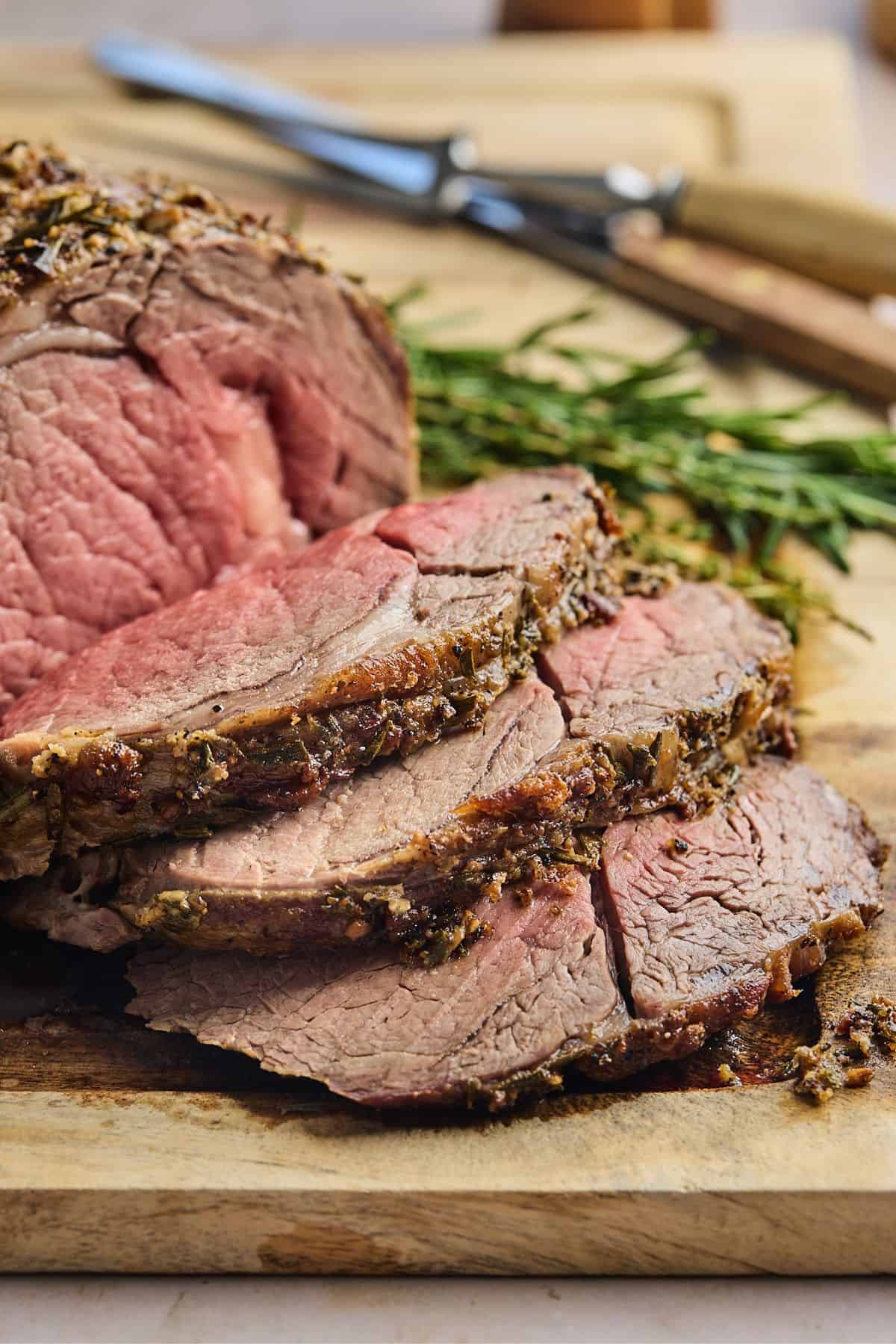 Slices of juicy prime rib recipe on a wooden cutboard