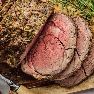 Juicy prime rib recipe sliced on a wooden cutboard