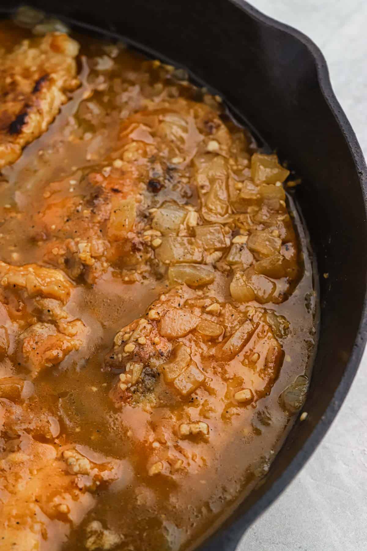 Closeup of turkey chops with gravy in a skillet