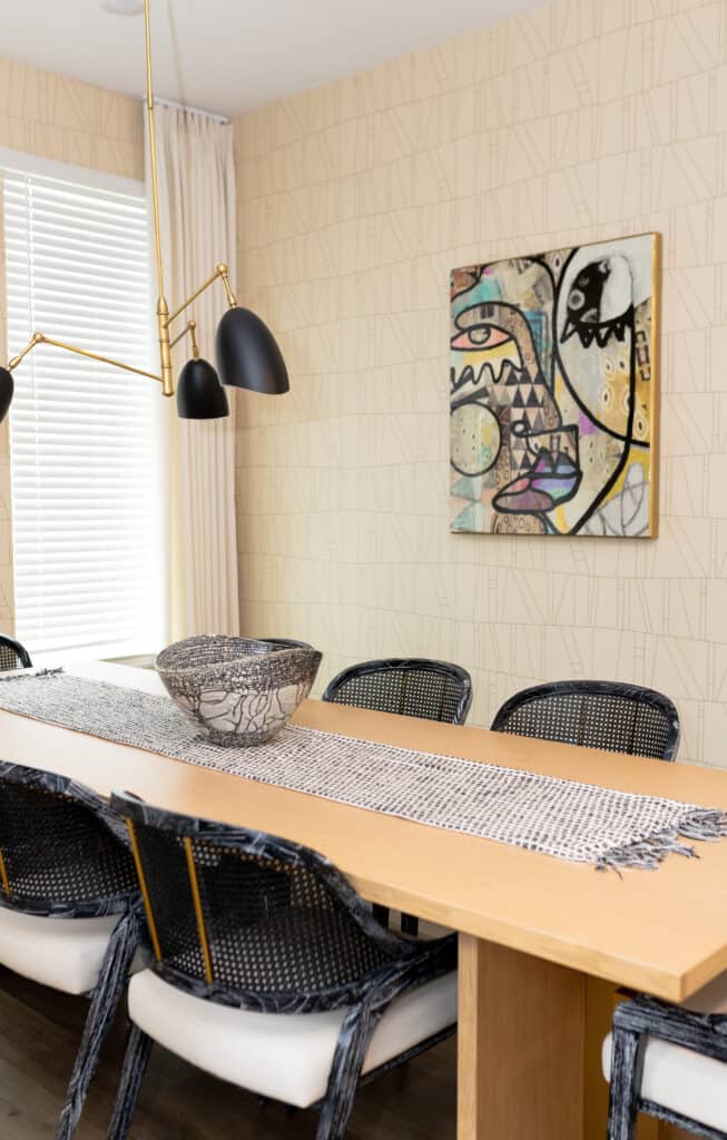 A shot of the full dining room with art and black and gold seating