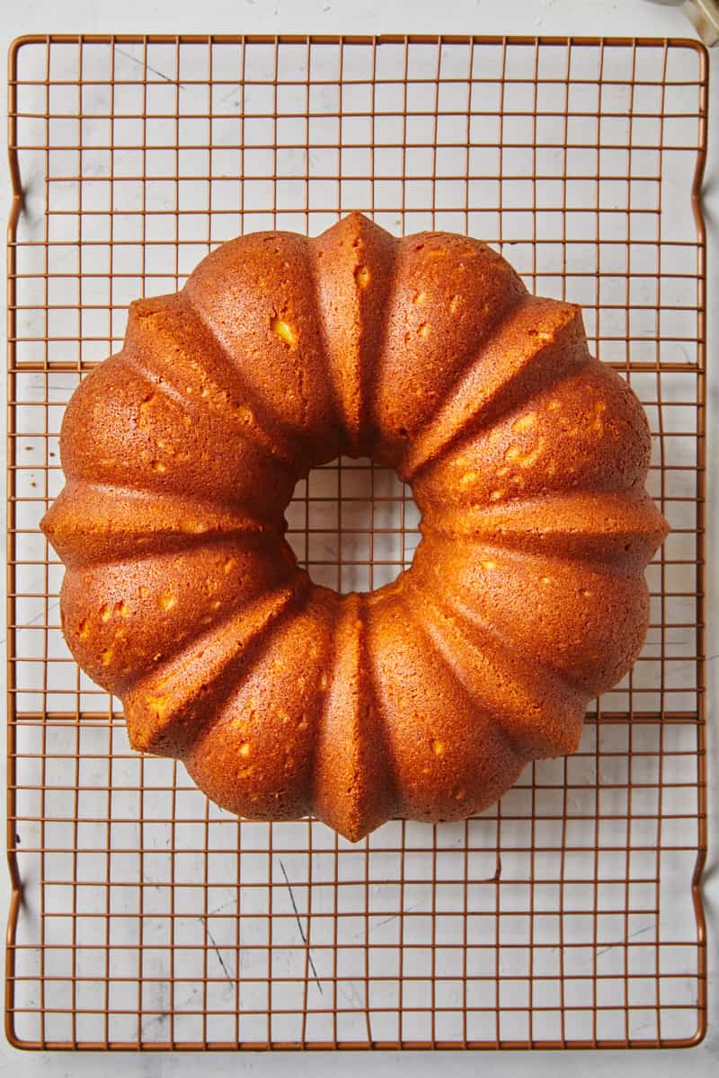 Pumpkin bundt cake recipe resting on a wire rack before icing.