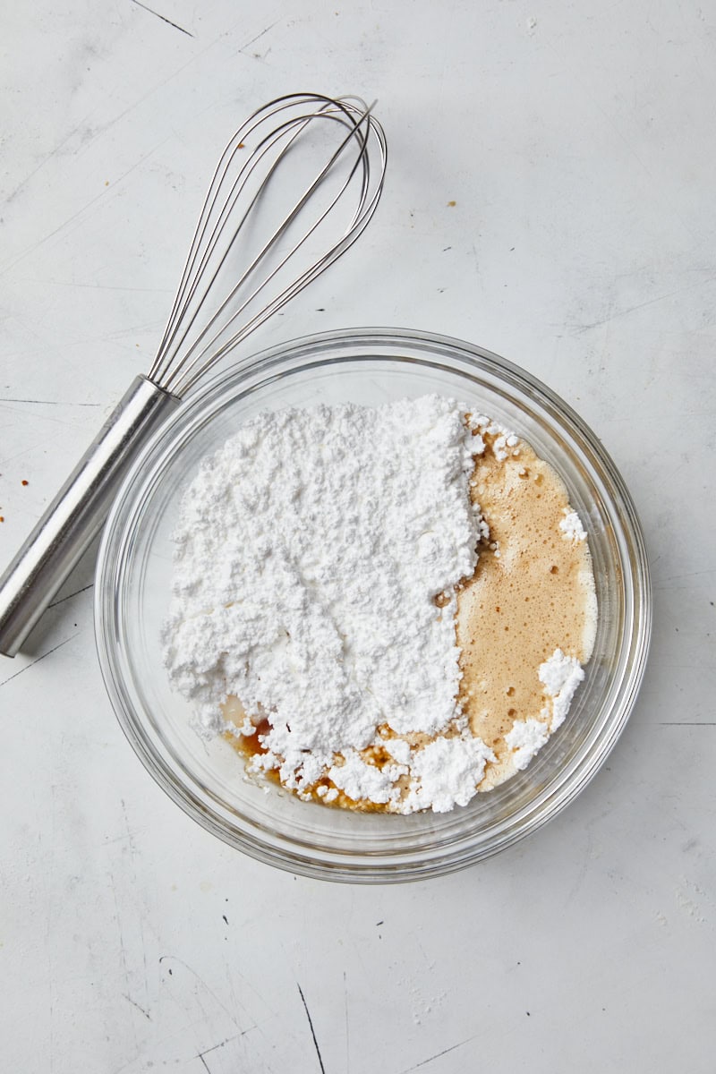 Brown butter glaze being mixed in a glass bowl with a whisk