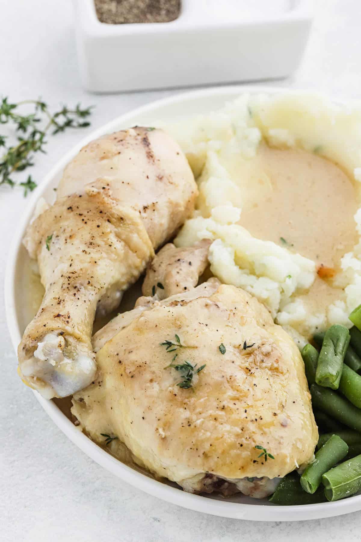 Chicken and gravy in a plate with mashed potatoes and green beans
