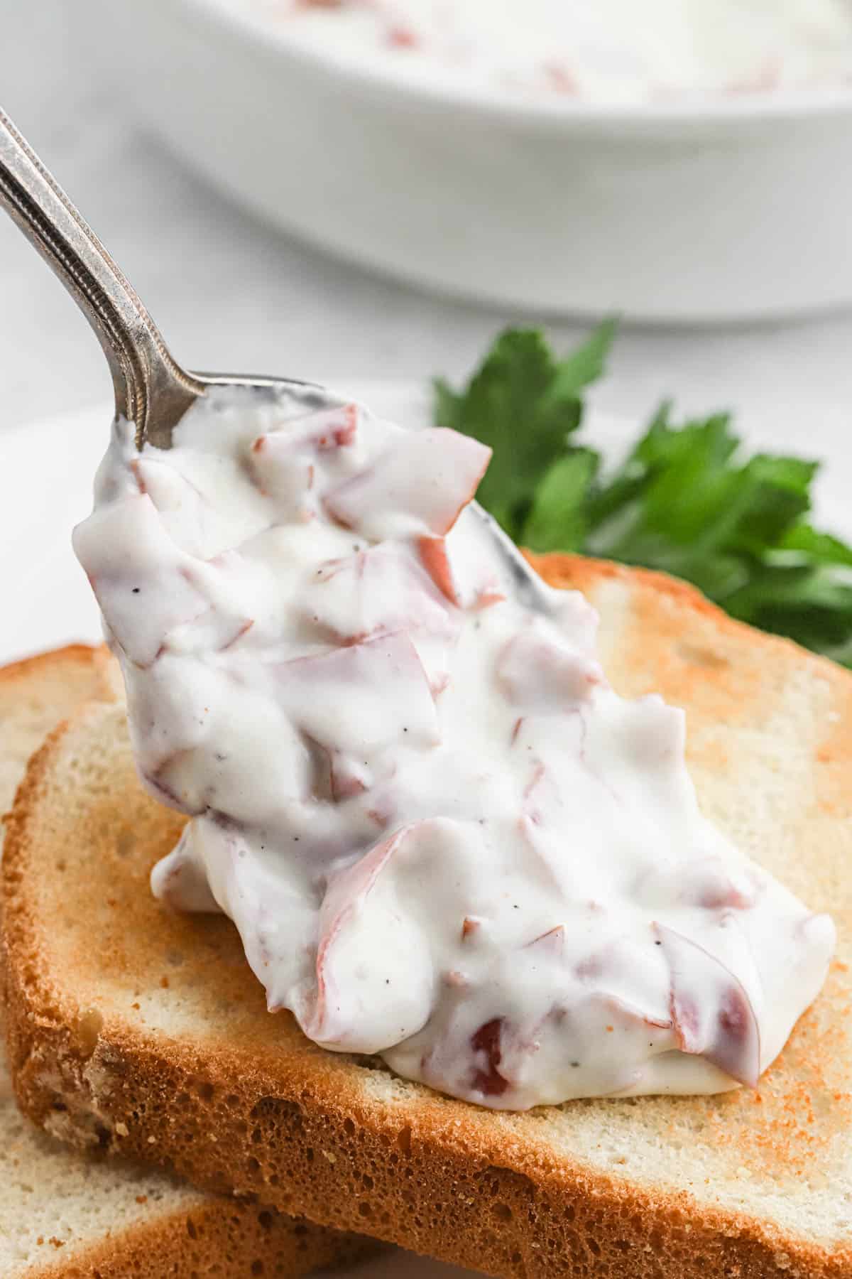 Metal spoon serving chipped beef gravy on toast