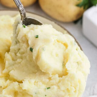 A spoon digging into creamy cream cheese mashed potatoes