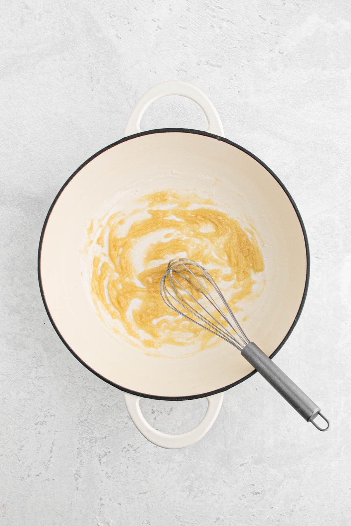 Butter and flour being whisked together to form a roux.