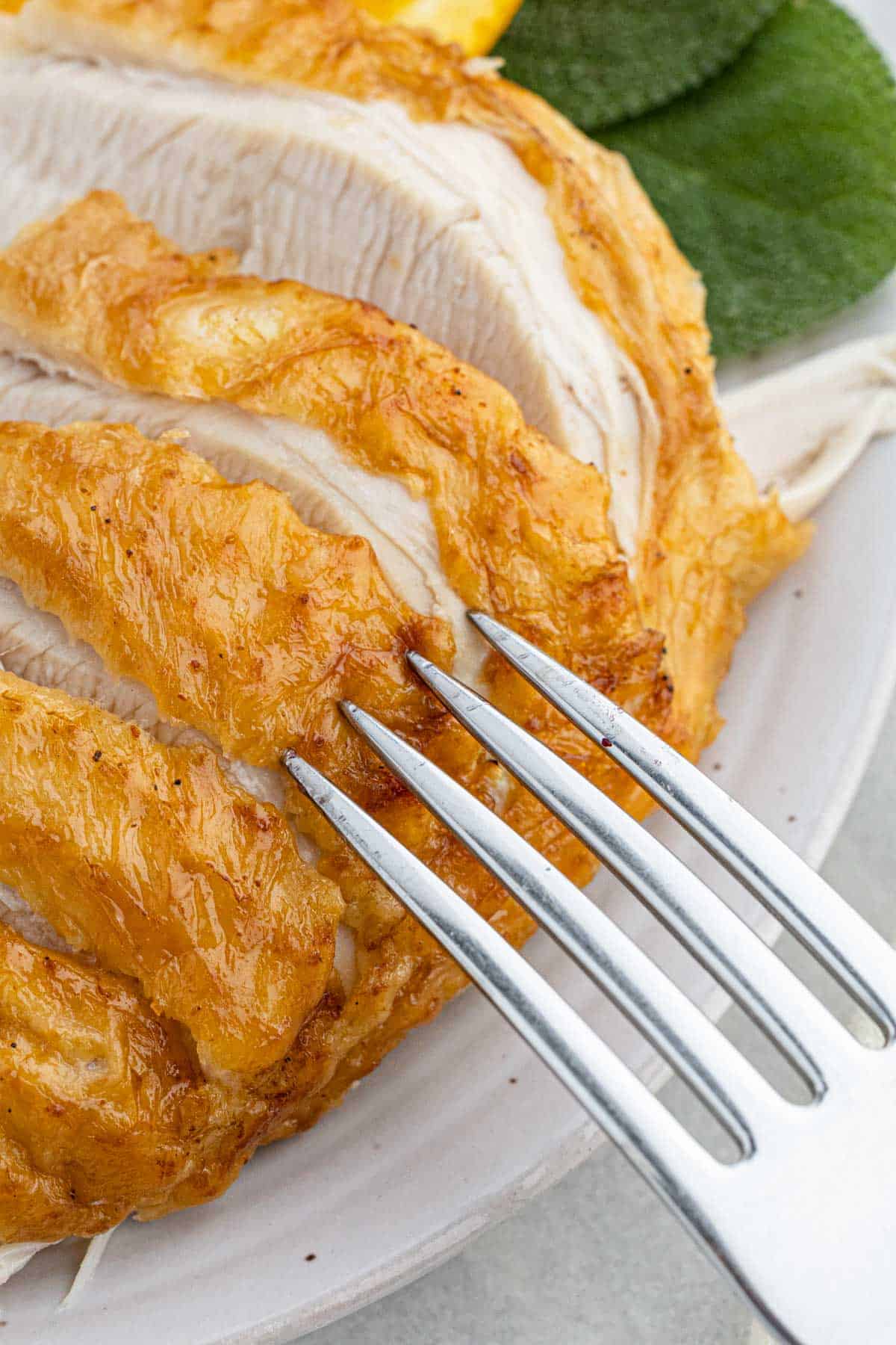 Close-up of a fork piercing crispy, golden-brown fried turkey slices