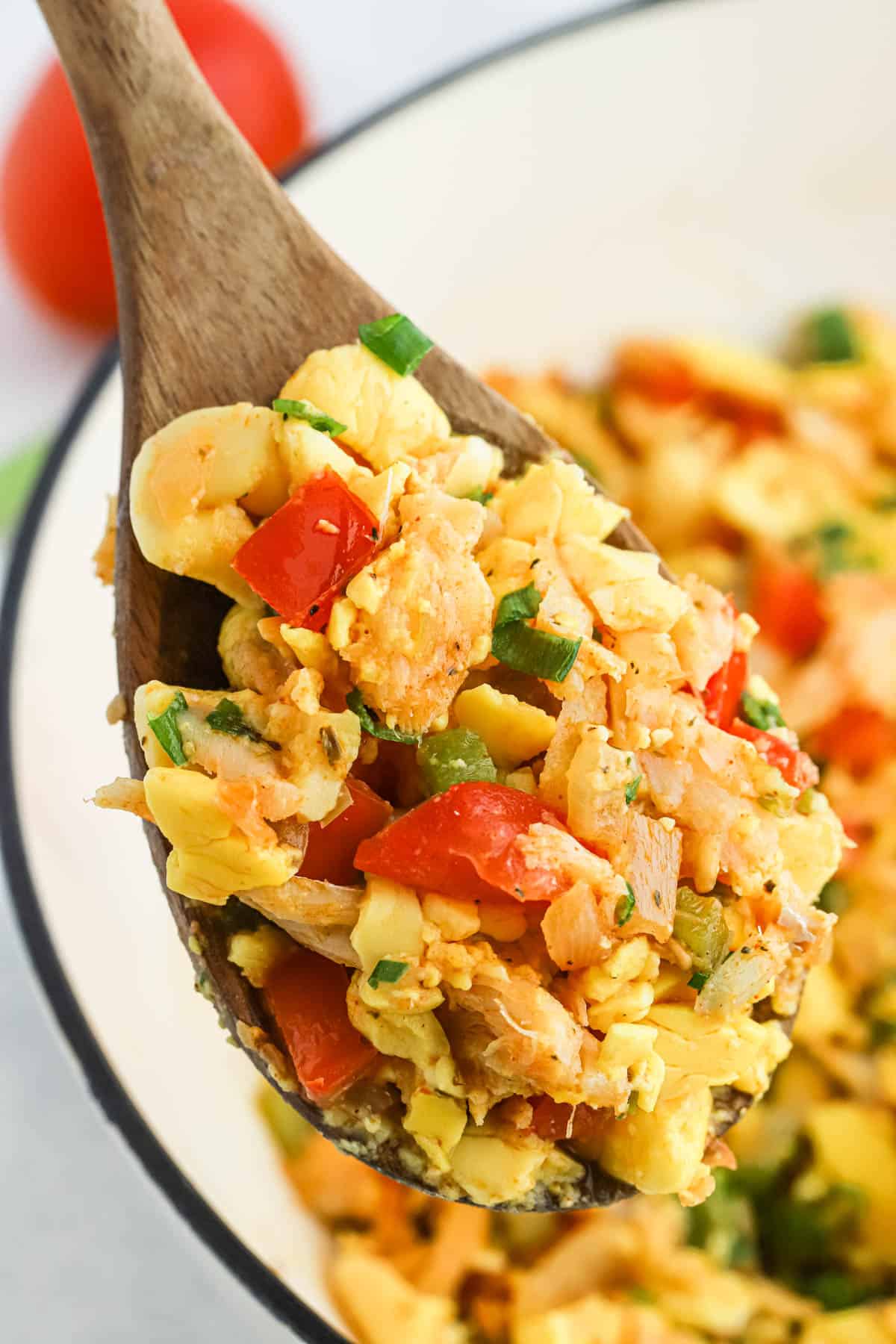 Close up of saltfish and ackee in a wooden spoon
