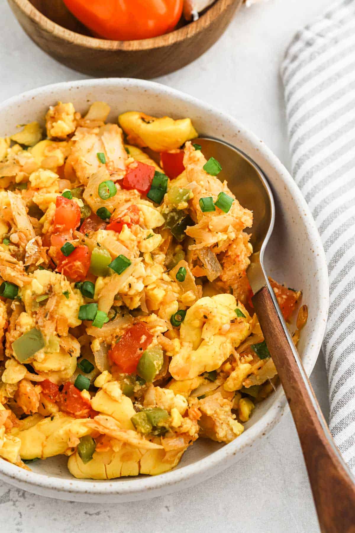 Saltfish and ackee in a white bowl with a spoon
