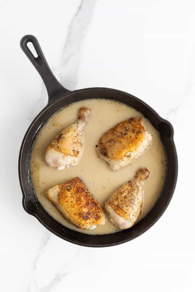 Chicken added to gravy in a cast iron skillet