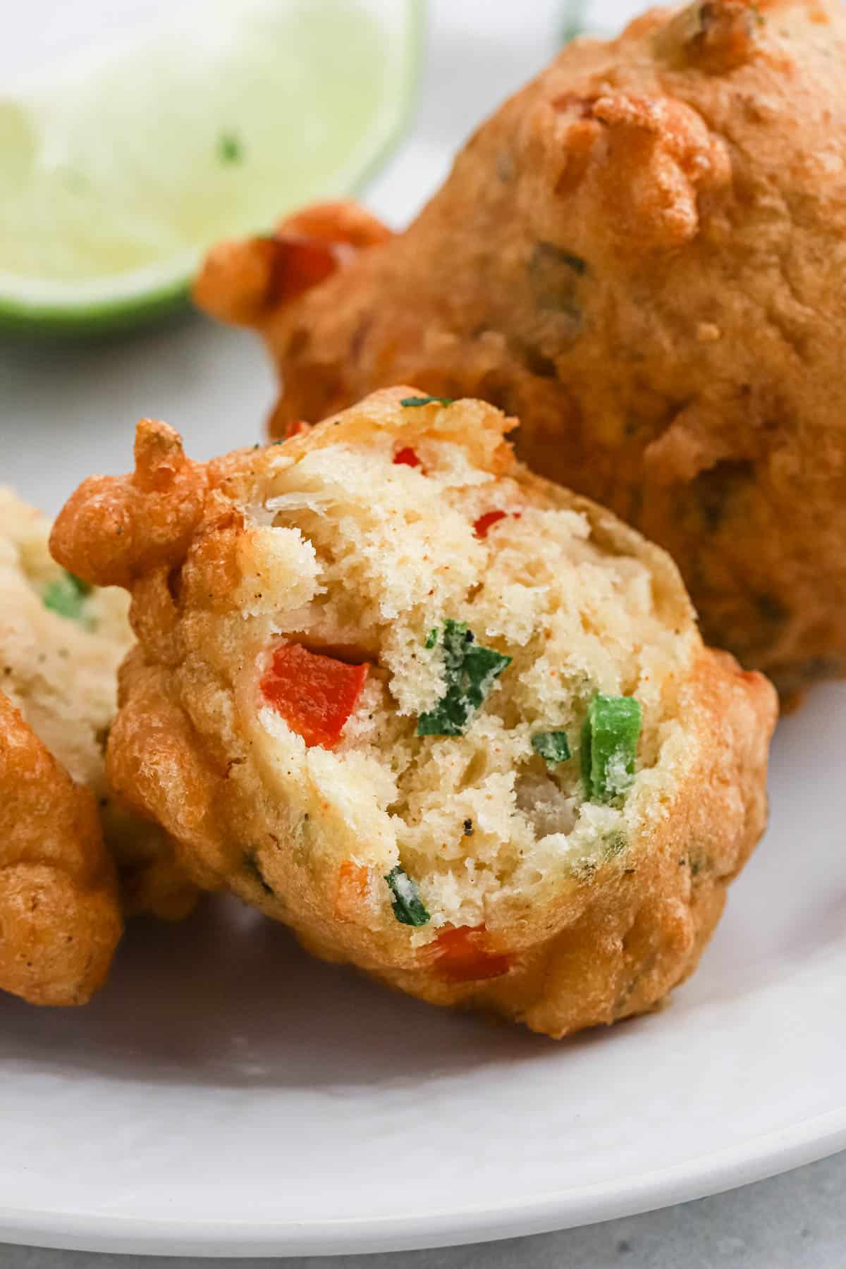 Close up of a saltfish fritter with a bite missing showing the inside