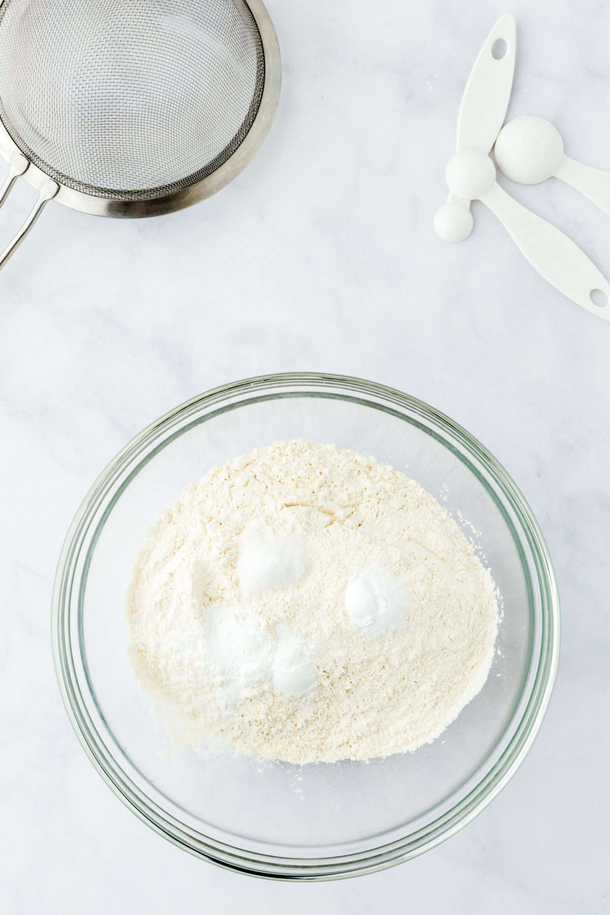 Dry ingredients in a glass bowl on a white countertop