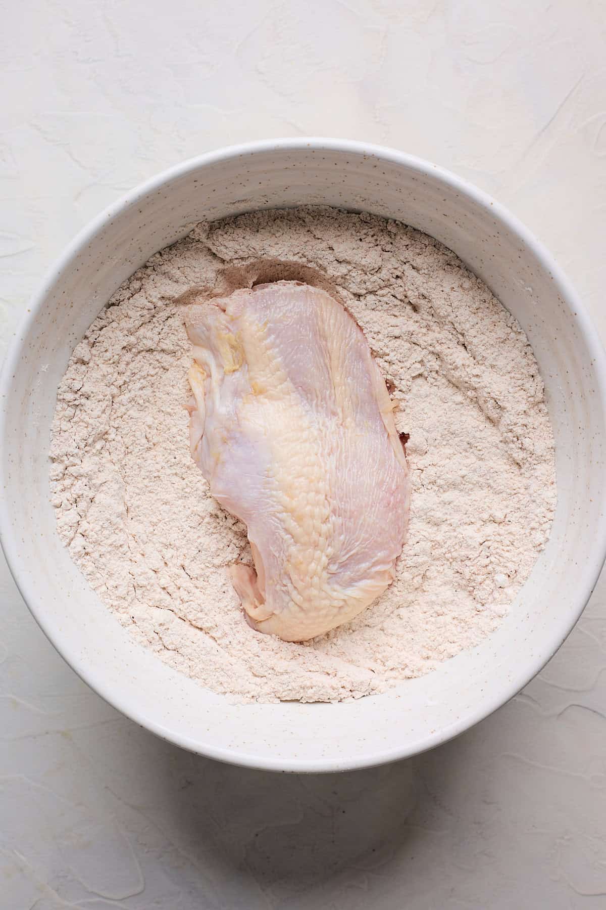 Piece of chicken in seasoned flour