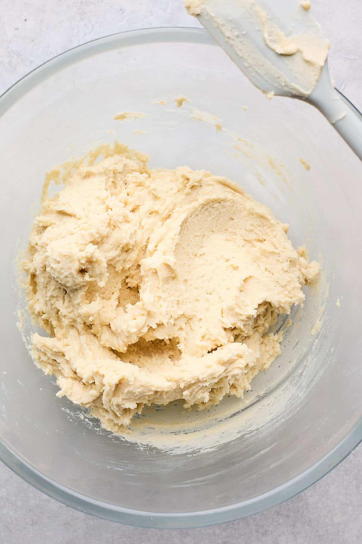 Finished tea cake cookie batter in a glass bowl after being mixed with a hand mixer