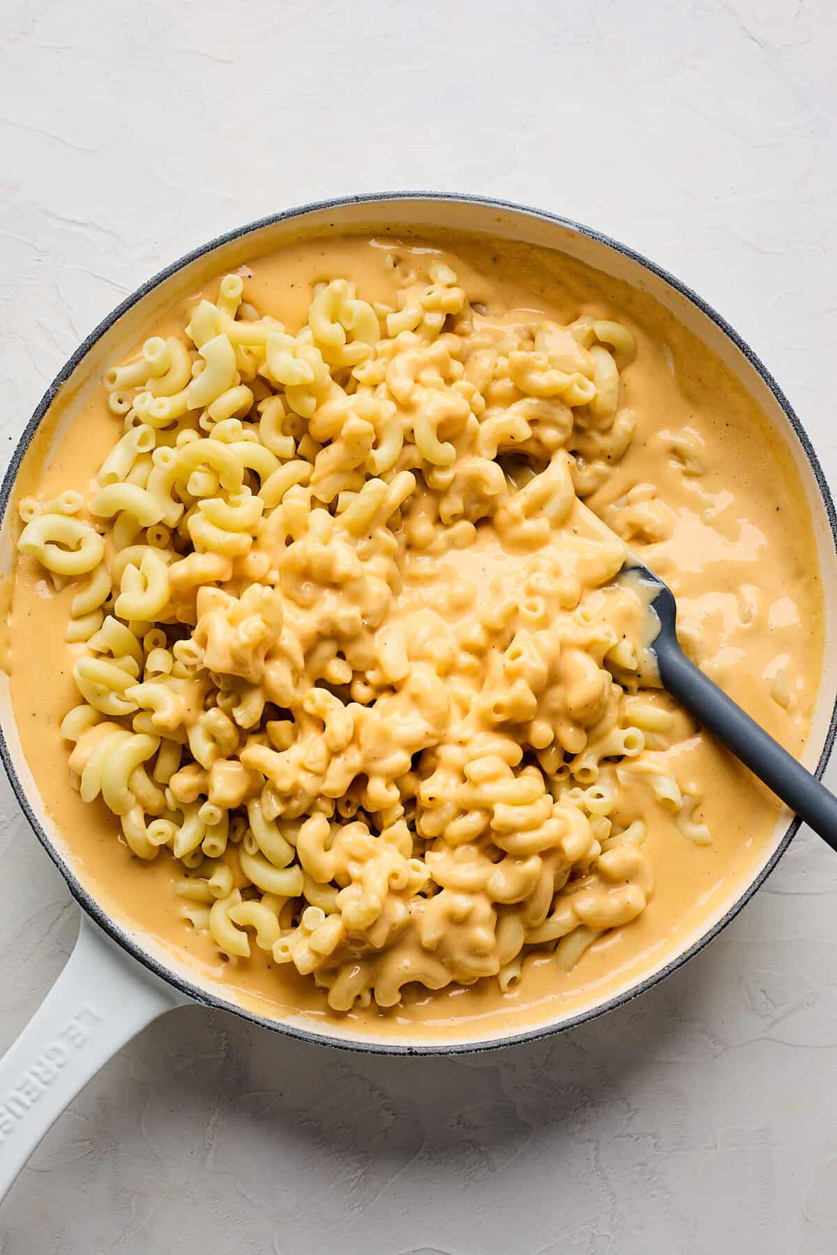 Velveeta macaroni being folded together in sauce