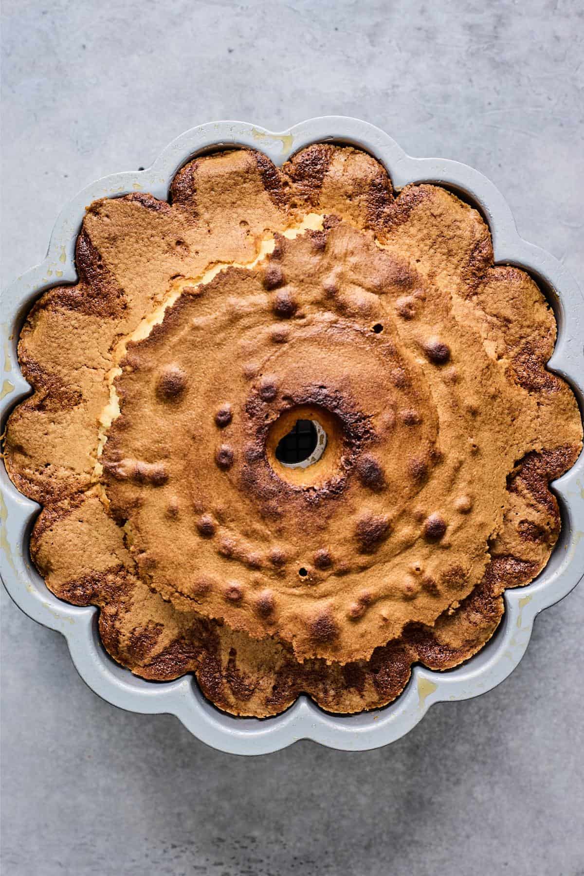 Baked bundt cake in a patterned pan, slightly browned and evenly risen