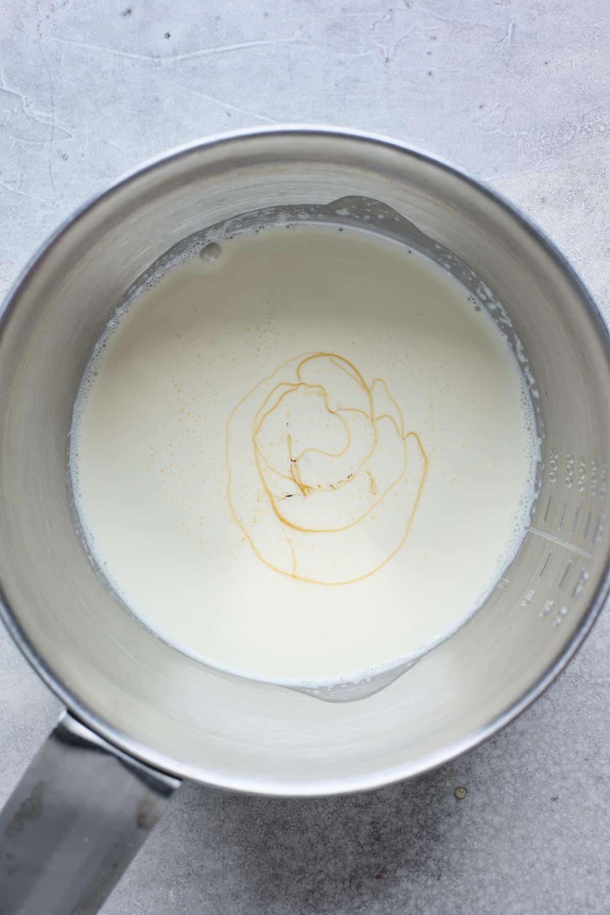 A saucepan with cream and a swirl of corn syrup visible