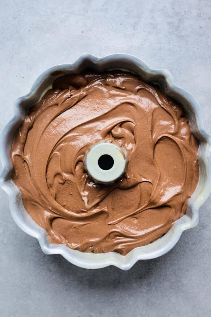 Chocolate batter spread evenly in a greased Bundt pan
