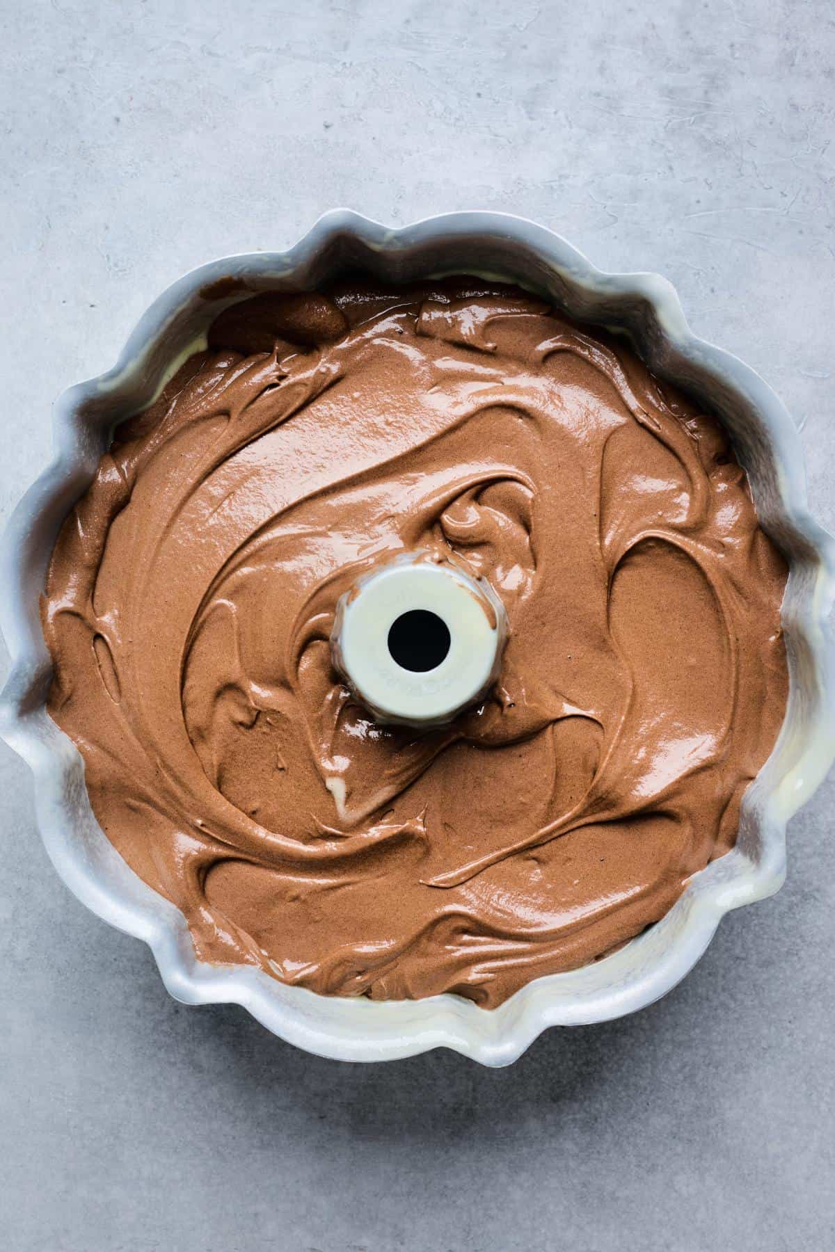 Chocolate batter spread evenly in a greased Bundt pan