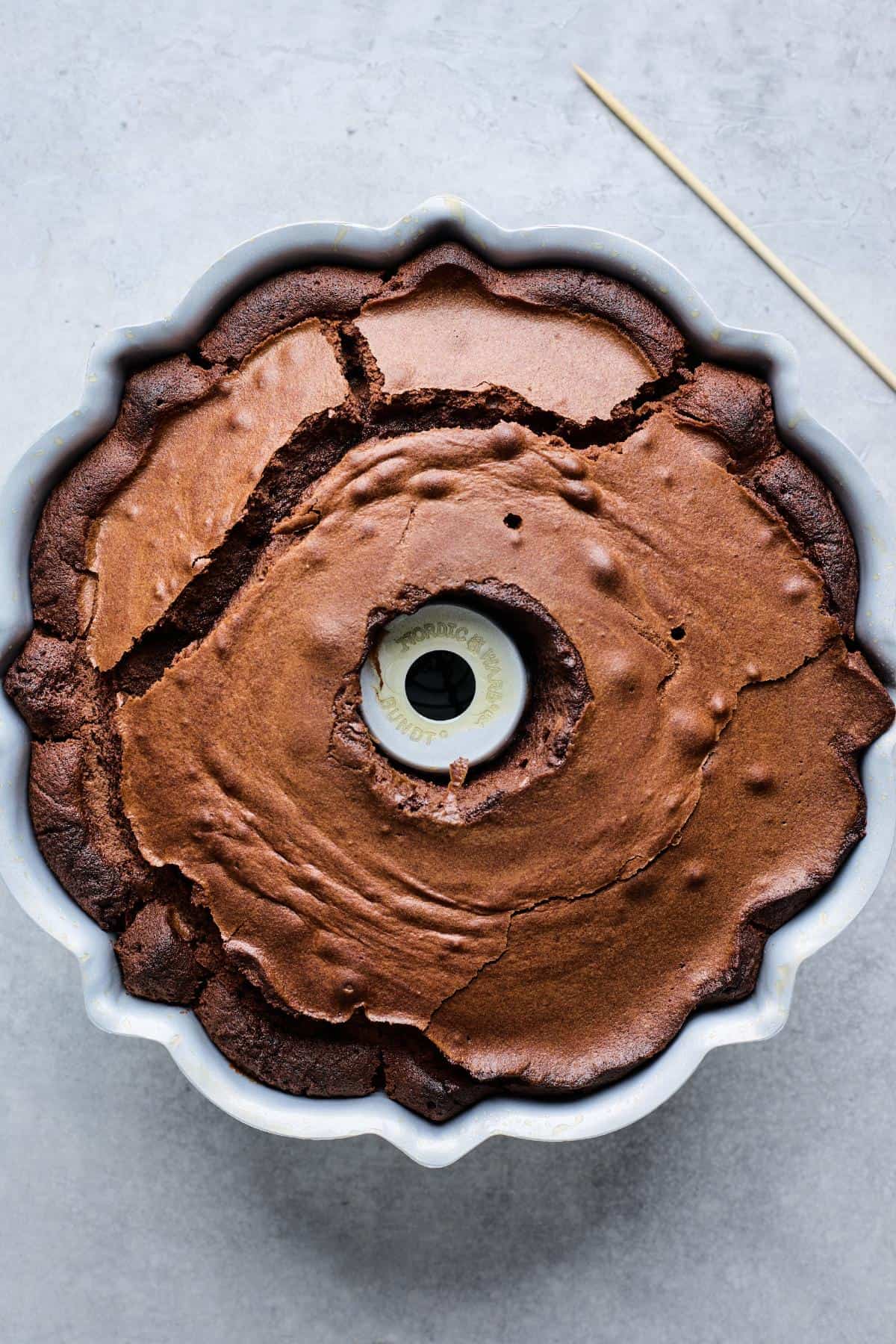 Baked chocolate pound cake in the Bundt pan, with a golden crust and cracks on top