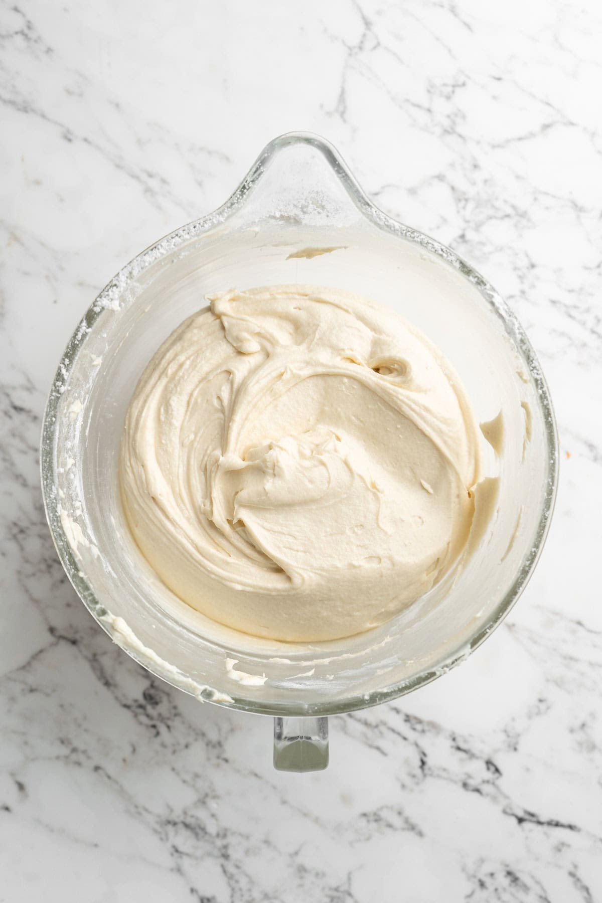 Completed coconut pound cake recipe batter in a stand mixer bowl on white countertop