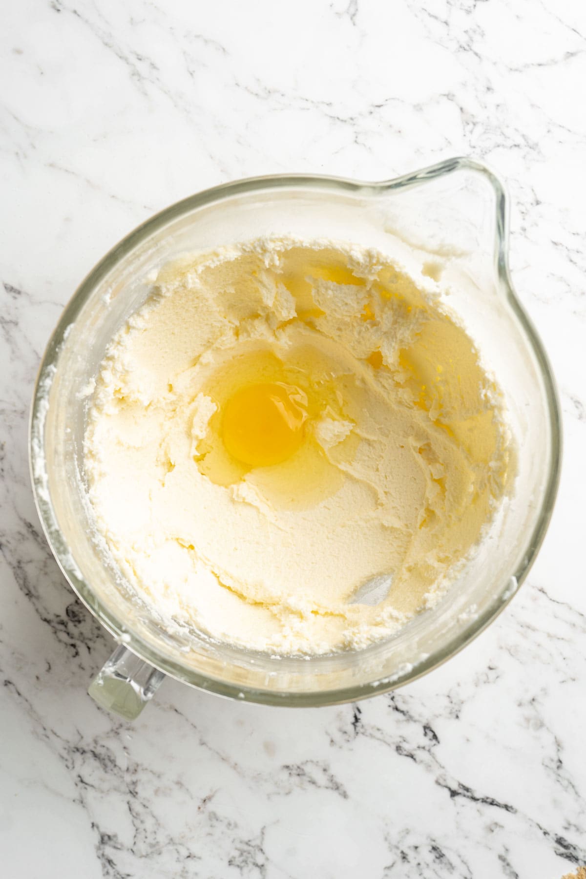 Eggs added to a stand mixer bowl ready to mix on white countertop