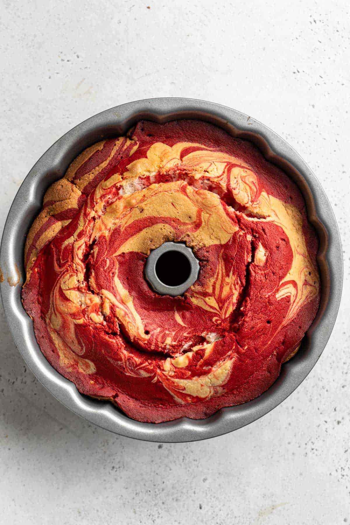 Baked red velvet marble bundt in a bundt pan after coming out of the oven