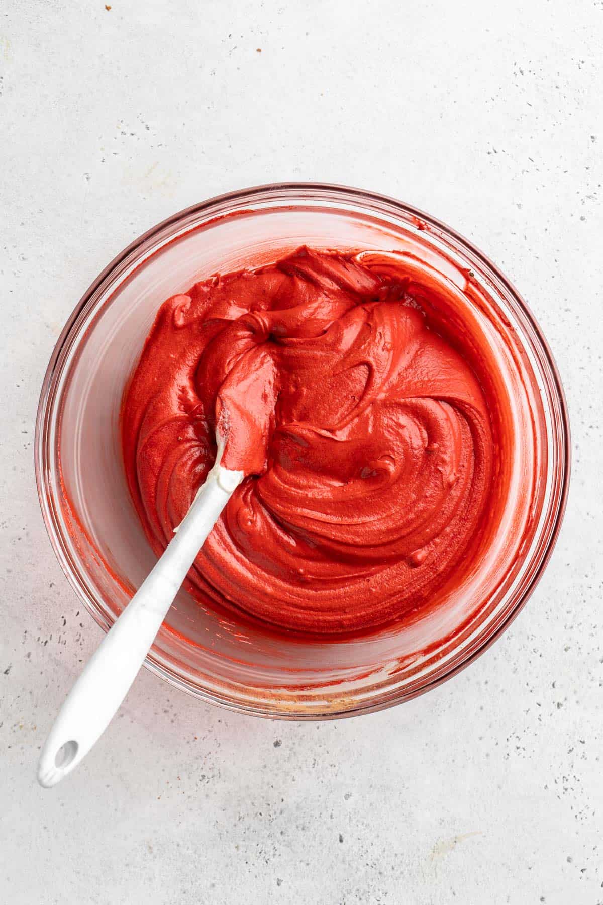 Mixed red velvet cake batter in a glass bowl