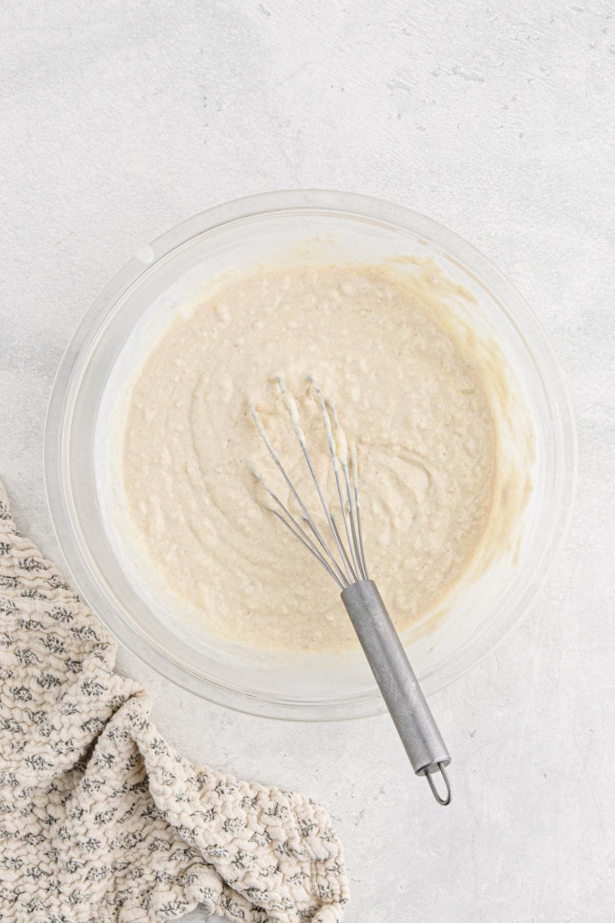 Waffle batter mixed until smooth in a bowl with a whisk