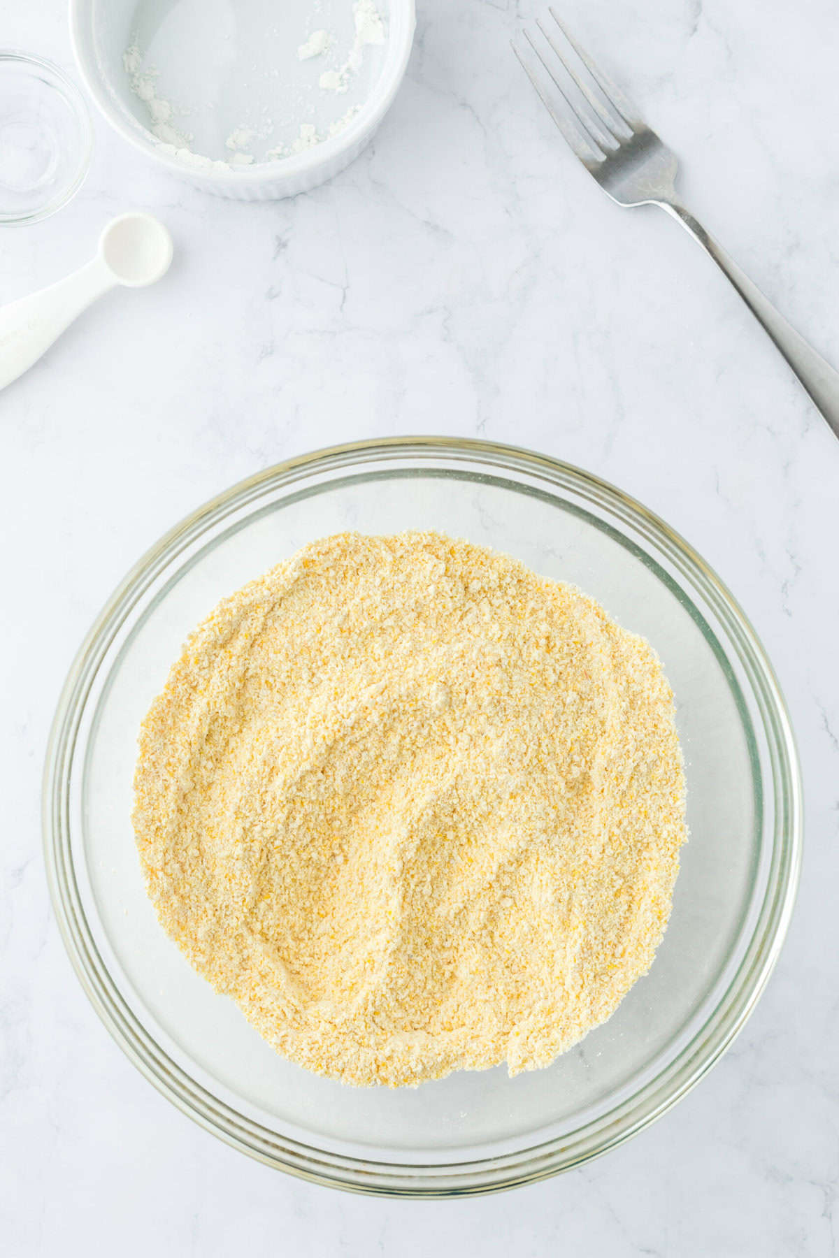 Cornbread dry ingredients in a glass bowl after being combined