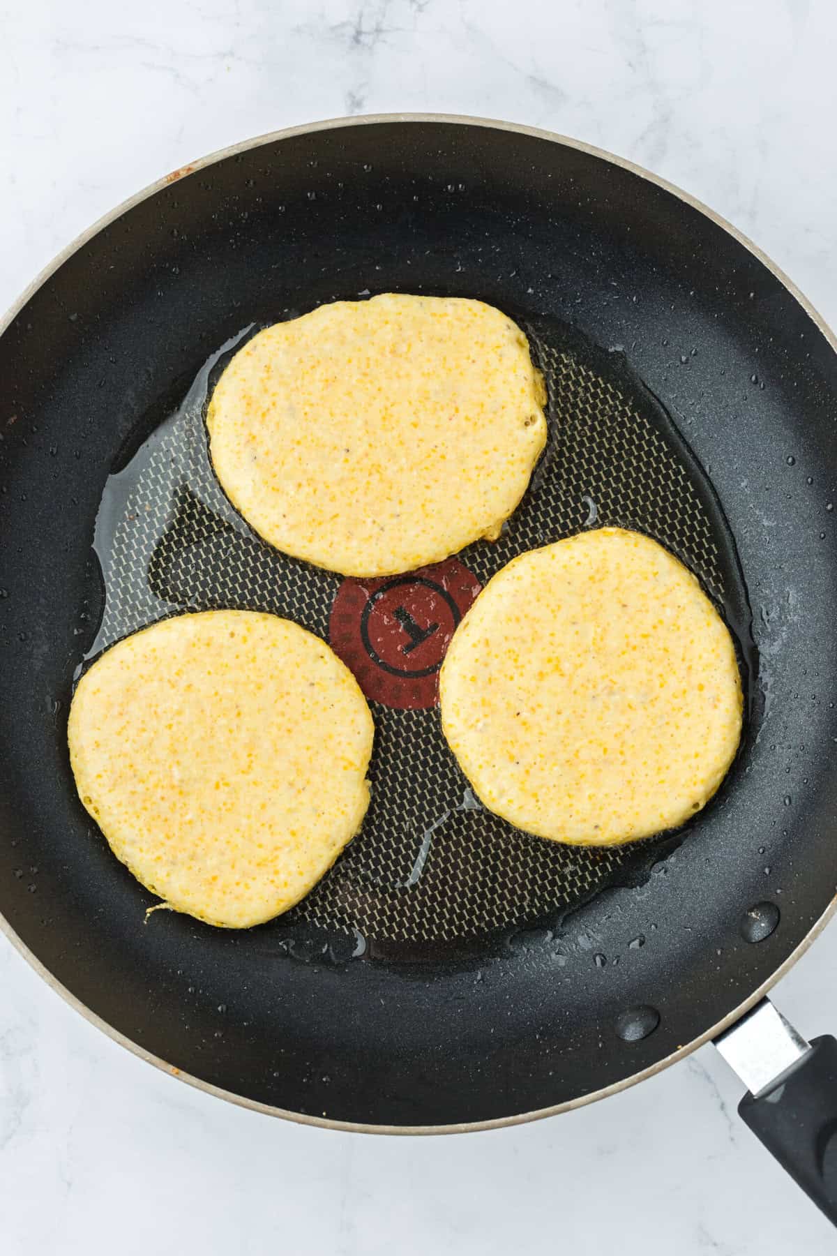 Cornbread batter being fried in a skillet