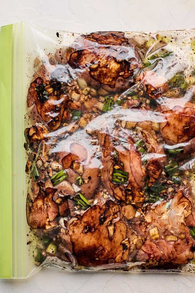 Brown stew chicken marinade in a ziptop bag with chicken inside