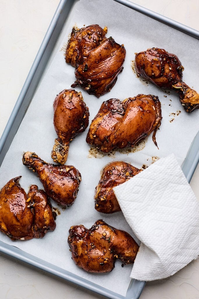 Marinated chicken on a lined baking sheet