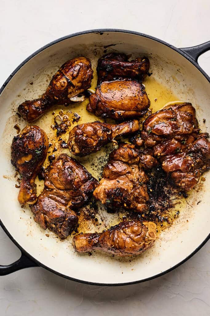 Marinated chicken frying in a large skillet