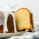 A close up of slice of million dollar pound cake being removed from whole cake