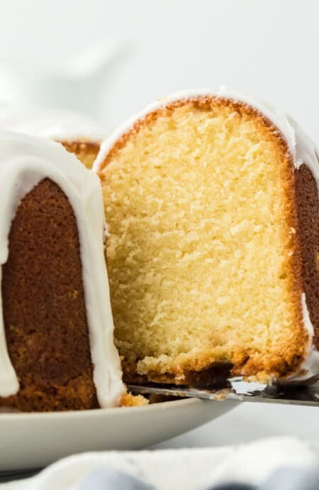 Close up of a slice of million dollar pound cake being pulled out of the cake with a cake server