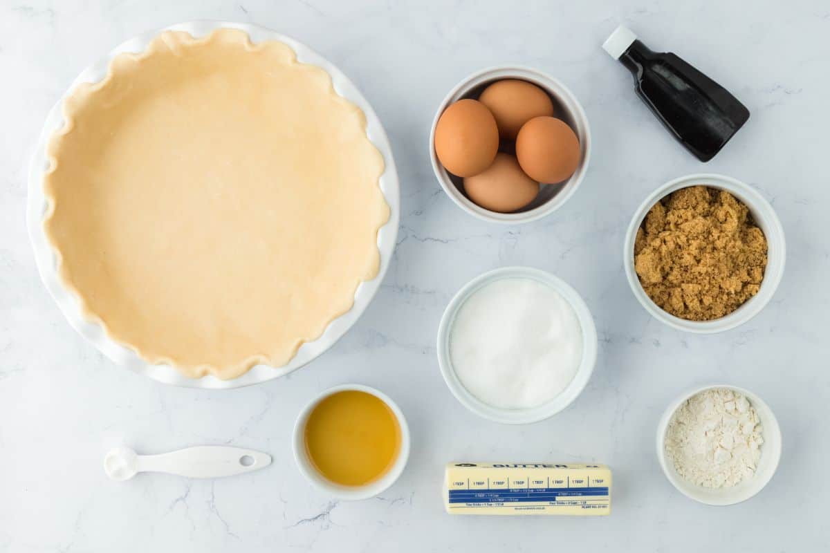 Overhead shot of ingredients to make vinegar pie on a white surface before mixing