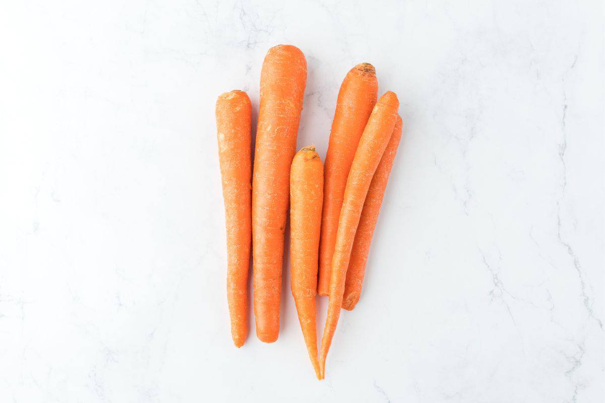 Overhead shot of carrots for making carrot puree on the table before peeling